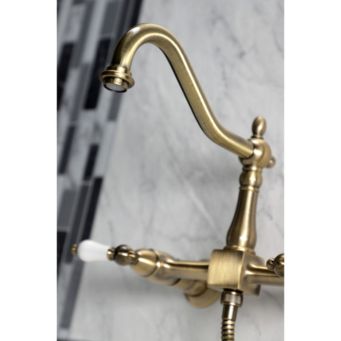 Kingston Heirloom KS1243PLBS - Heritage Two-Handle 3-Hole Wall Mount Bridge Kitchen Faucet with Brass Sprayer, Antique Brass